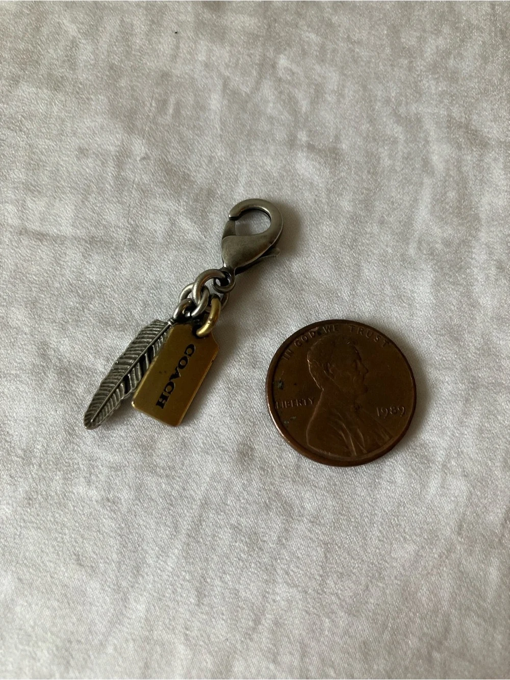 Coach: Silver Tone & Gold Tone Feather Charm Keyring